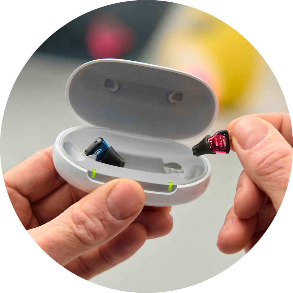 Signia Silk IX portable charging case in hands