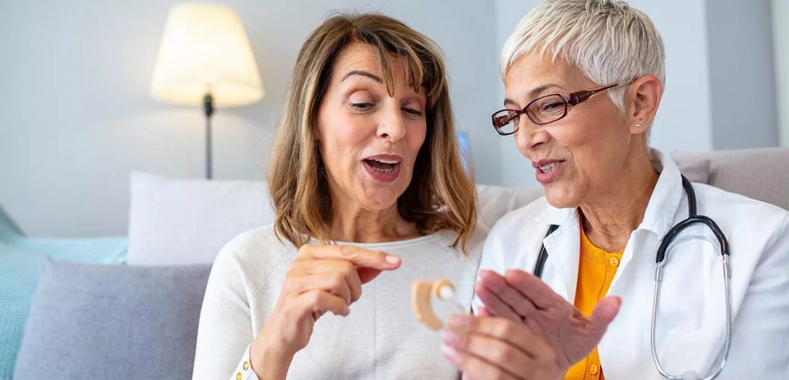 Adults discussing how to clean a hearing aid