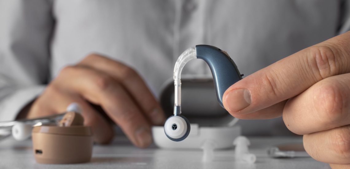 man holding hearing aids